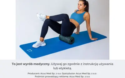 Kobieta na macie ćwiczy, jak masować mięsień gruszkowaty za pomocą rollera.