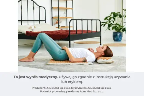 Kobieta leży na macie akupresurowej, relaksując się. To może być sposób na ulgę w bólach głowy.
