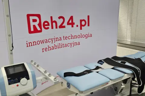 Łóżko rehabilitacyjne z pasami do dekompresji kręgosłupa i aparaturą do terapii.