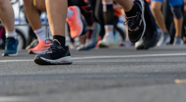 Nogi biegaczy w butach sportowych na trasie. To właśnie jest jogging, czyli bieganie dla zdrowia i przyjemności.