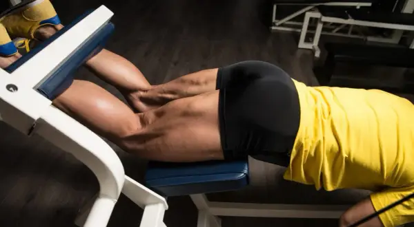 Mięśnie ud pracują podczas ćwiczenia leg curl na siłowni.