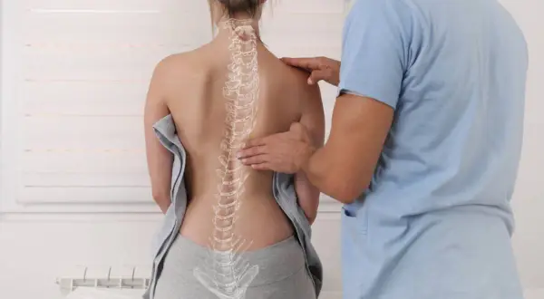 Chiropratyka co to? Terapeuta bada kręgosłup pacjentki, pomagając zrozumieć jego budowę i funkcje.