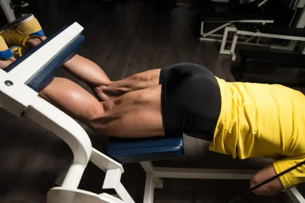 Mięśnie ud pracują podczas ćwiczenia leg curl na siłowni.