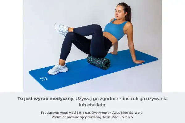 Kobieta wykonuje test na mięsień gruszkowaty, używając rollera do masażu na macie.