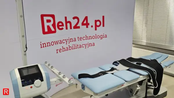 Łóżko rehabilitacyjne z pasami do dekompresji kręgosłupa i aparaturą do terapii.